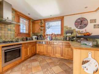This charming kitchen boasts a warm, inviting atmosphere with its wooden cabinetry and tiled backsplash.