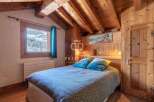 Discover the charm of this cozy bedroom, featuring a stunning wooden ceiling and walls that exude warmth.