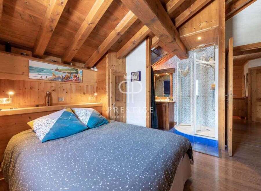 Discover the charm of this cozy bedroom with its rustic wooden beams and inviting ambiance.
