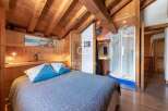 Discover the charm of this cozy bedroom with its rustic wooden beams and inviting ambiance.