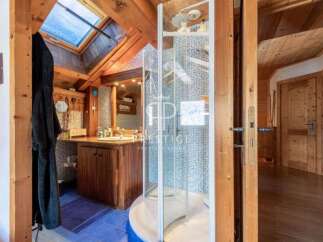 Discover the charm of this rustic bathroom, featuring a unique skylight and wooden accents.