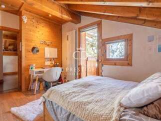 Discover the charm of this cozy bedroom, featuring warm wooden accents and a serene atmosphere.