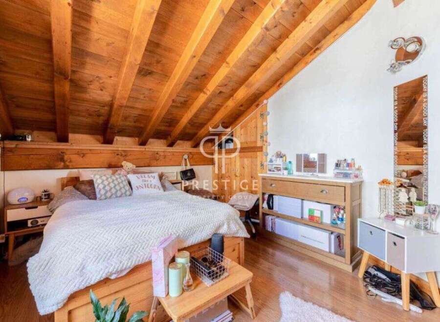 This charming bedroom features a unique wooden sloped ceiling, creating a cozy and inviting atmosphere.