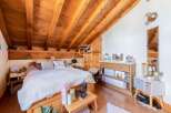 This charming bedroom features a unique wooden sloped ceiling, creating a cozy and inviting atmosphere.