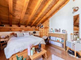 This charming bedroom features a unique wooden sloped ceiling, creating a cozy and inviting atmosphere.