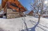 Discover the charm of this stunning wooden chalet nestled in a snowy landscape.