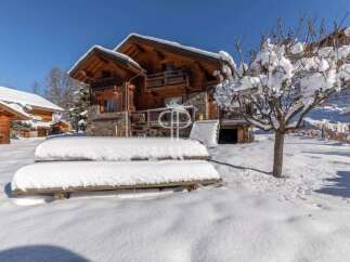 Experience the charm of a snow-covered chalet nestled in a picturesque winter wonderland.