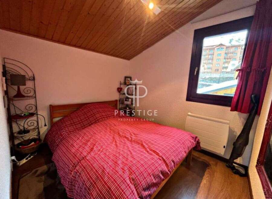 Cozy bedroom with a comfortable bed and a charming red and white patterned duvet.