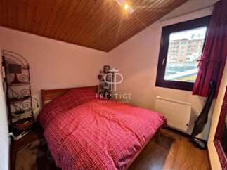 Cozy bedroom with a comfortable bed and a charming red and white patterned duvet.