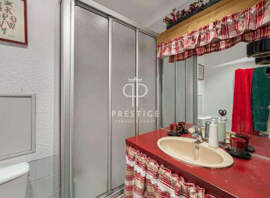 Charming bathroom with a unique red countertop and a stylish sink.