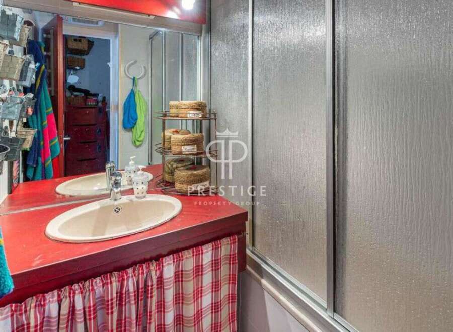 Discover a charming bathroom with a unique red countertop and a stylish sink.