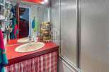 Discover a charming bathroom with a unique red countertop and a stylish sink.