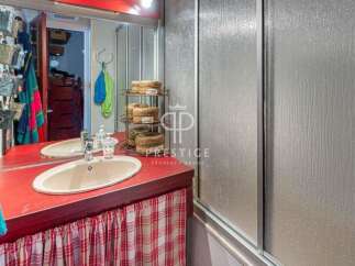 Discover a charming bathroom with a unique red countertop and a stylish sink.