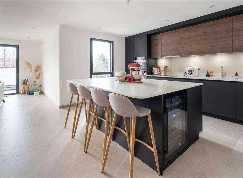 Stunning open-plan kitchen and living area with modern dark cabinetry and a large island.