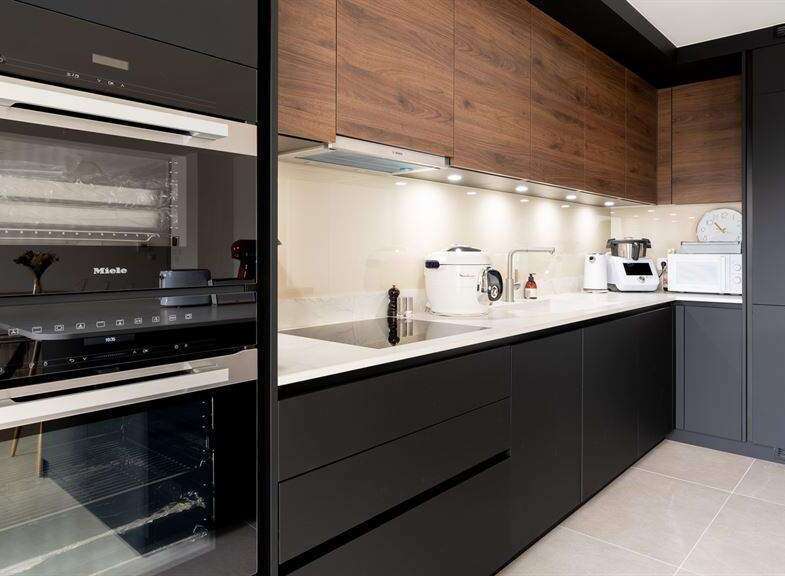 Modern kitchen with sleek black cabinetry and wood accents.