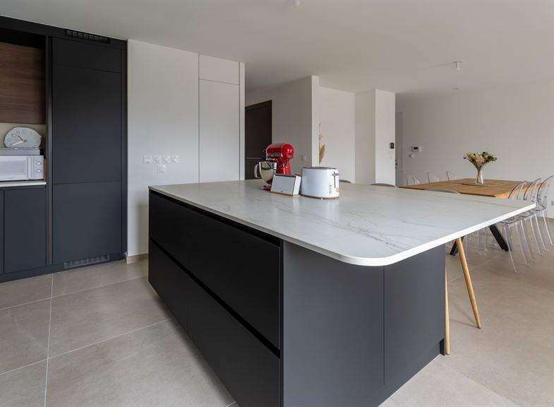 Modern kitchen with sleek dark cabinetry and a stunning marble island.