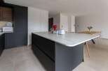 Modern kitchen with sleek dark cabinetry and a stunning marble island.