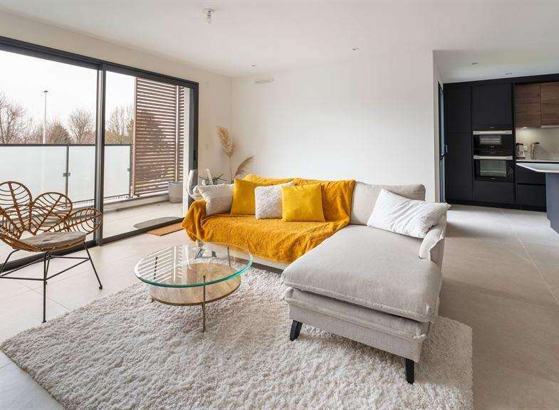 Stunning apartment boasting an open-plan living area with floor-to-ceiling windows offering ample natural light and access to a private balcony.