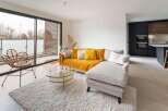Stunning apartment boasting an open-plan living area with floor-to-ceiling windows offering ample natural light and access to a private balcony.