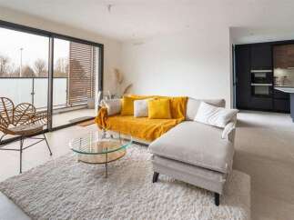 Stunning apartment boasting an open-plan living area with floor-to-ceiling windows offering ample natural light and access to a private balcony.