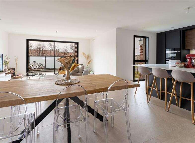 Stunning open-plan living space with a sleek modern kitchen and a large dining table perfect for entertaining.