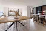 Stunning open-plan living space with a sleek modern kitchen and a large dining table perfect for entertaining.