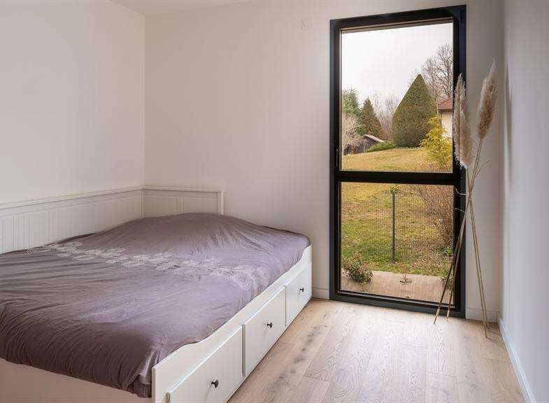 This bright bedroom features a comfortable bed with built-in drawers, perfect for storage.