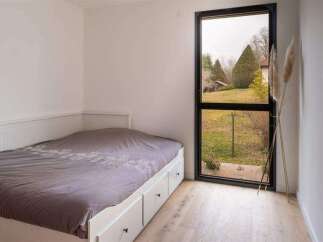 This bright bedroom features a comfortable bed with built-in drawers, perfect for storage.