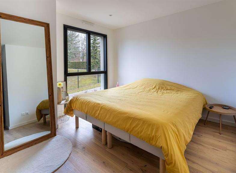 Bright bedroom with large window overlooking garden.
