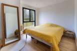 Bright bedroom with large window overlooking garden.