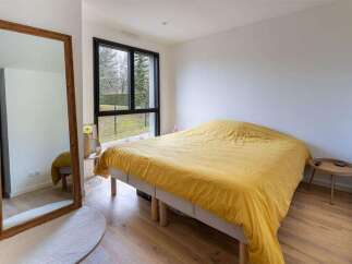 Bright bedroom with large window overlooking garden.