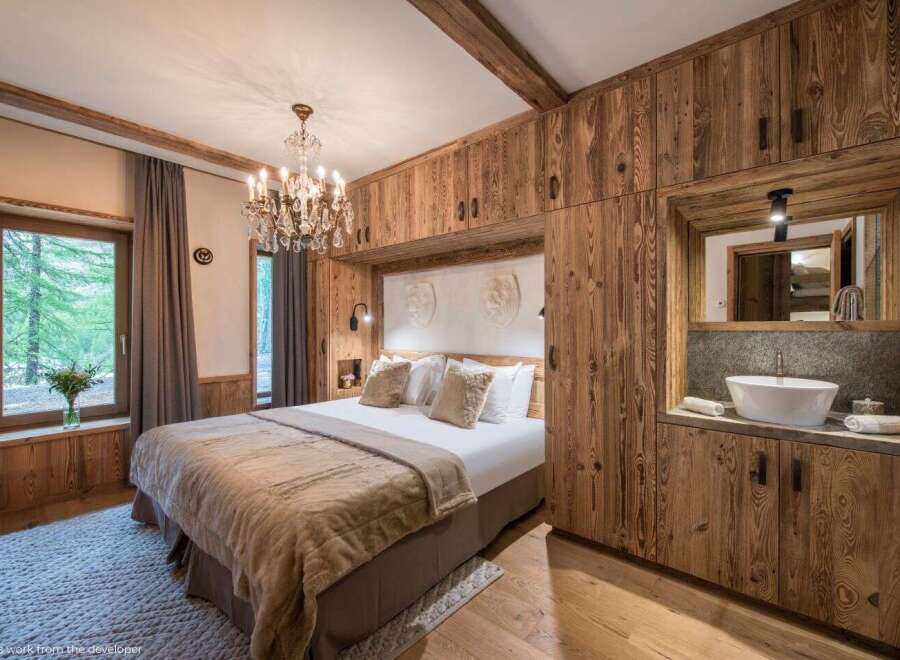 Experience luxury in this stunning bedroom featuring exquisite wooden paneling and a cozy ambiance.