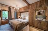Experience luxury in this stunning bedroom featuring exquisite wooden paneling and a cozy ambiance.