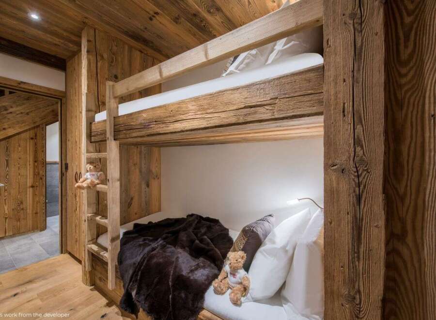 Experience rustic charm in this cozy bedroom featuring custom-built bunk beds.