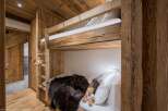 Experience rustic charm in this cozy bedroom featuring custom-built bunk beds.