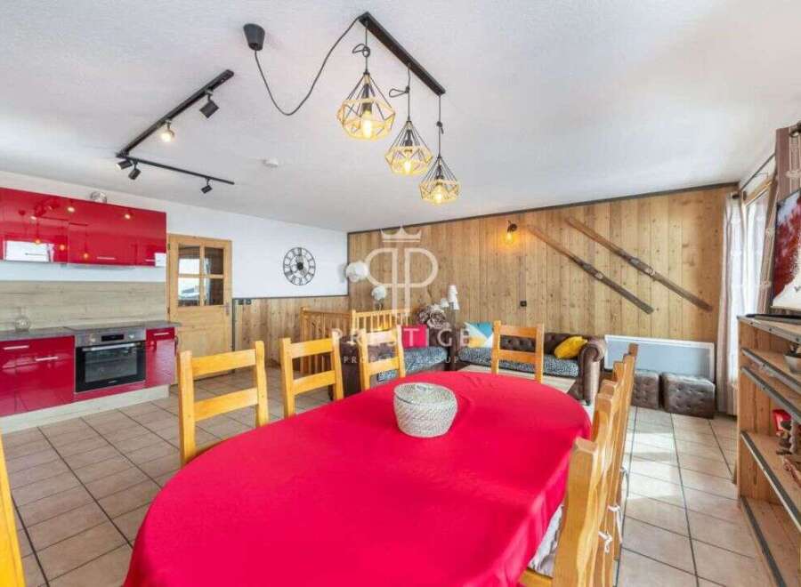 Discover the charm of this stunning property, featuring a vibrant red kitchen and a cozy dining area perfect for gatherings.