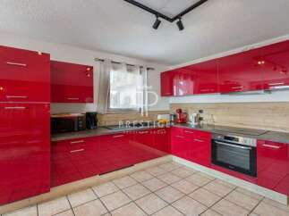 Discover modern living in this stunning kitchen! Featuring sleek red cabinetry, a built-in oven, and ample counter space, this kitchen is perfect for culinary enthusiasts.