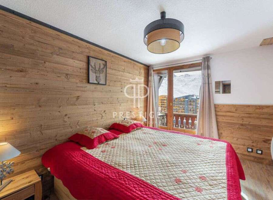 Cozy bedroom with wooden walls and a stunning view.