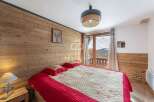 Cozy bedroom with wooden walls and a stunning view.