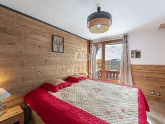 Cozy bedroom with wooden walls and a stunning view.
