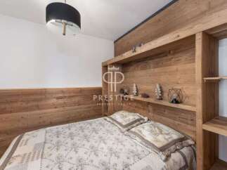 Discover the charm of this cozy bedroom, featuring a unique wooden headboard and built-in shelving.