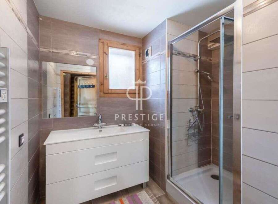 Discover a stylish bathroom featuring a modern vanity and a sleek glass shower enclosure.
