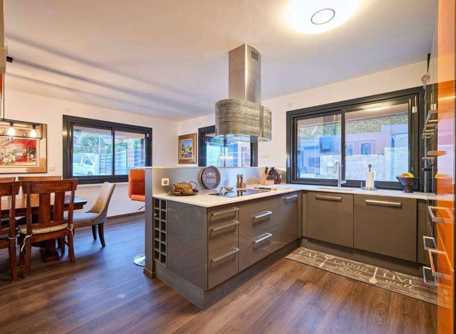 Stunning kitchen with modern gray cabinets and a sleek island, featuring a wine rack and ample counter space.