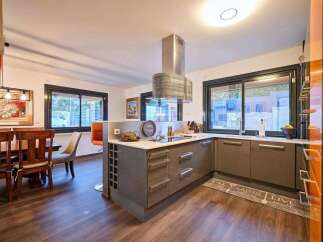 Stunning kitchen with modern gray cabinets and a sleek island, featuring a wine rack and ample counter space.