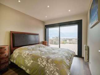 Wake up to breathtaking lake views from this luxurious bedroom.