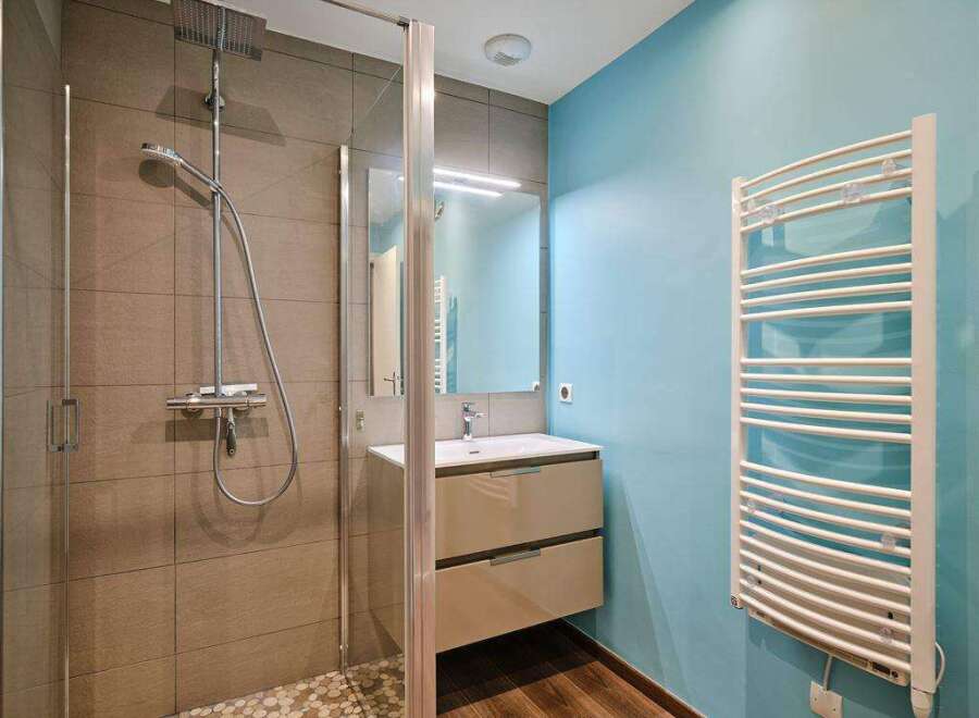 Modern bathroom with a walk-in shower, stylish vanity, and heated towel rack.