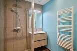 Modern bathroom with a walk-in shower, stylish vanity, and heated towel rack.