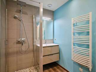 Modern bathroom with a walk-in shower, stylish vanity, and heated towel rack.