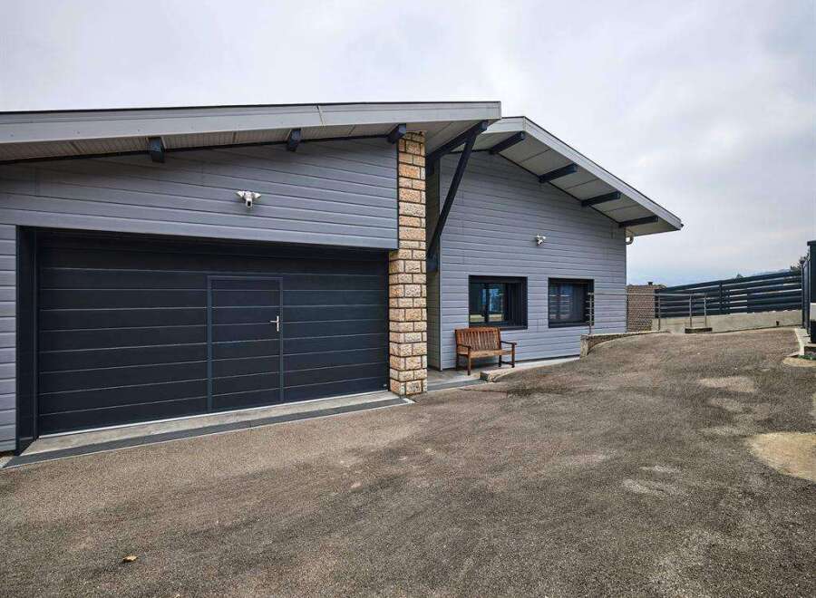 Modern house with attached garage and spacious driveway.