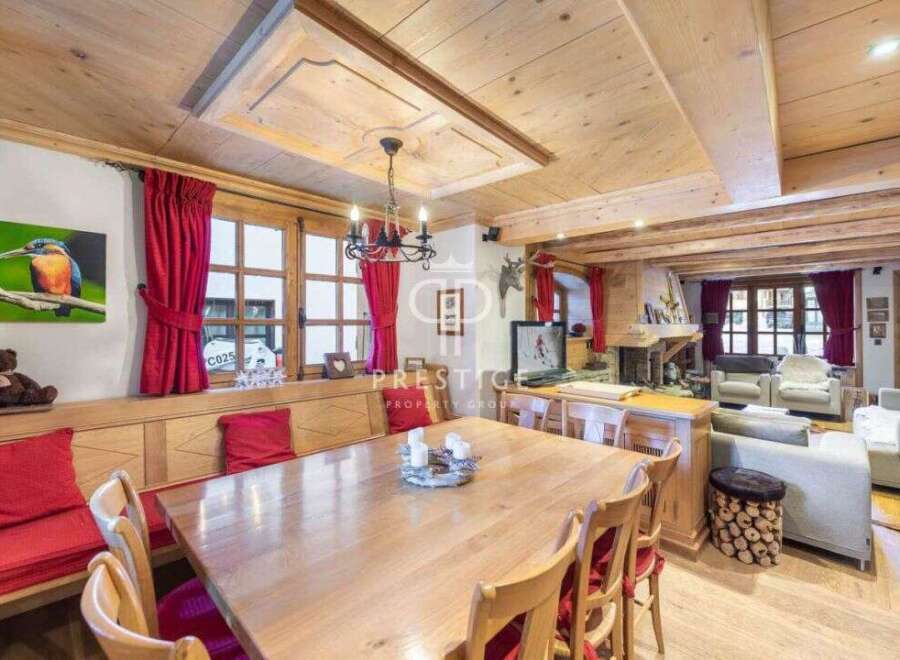 Experience the charm of this stunning property, featuring a warm and inviting dining area with a large wooden table, perfect for gatherings.